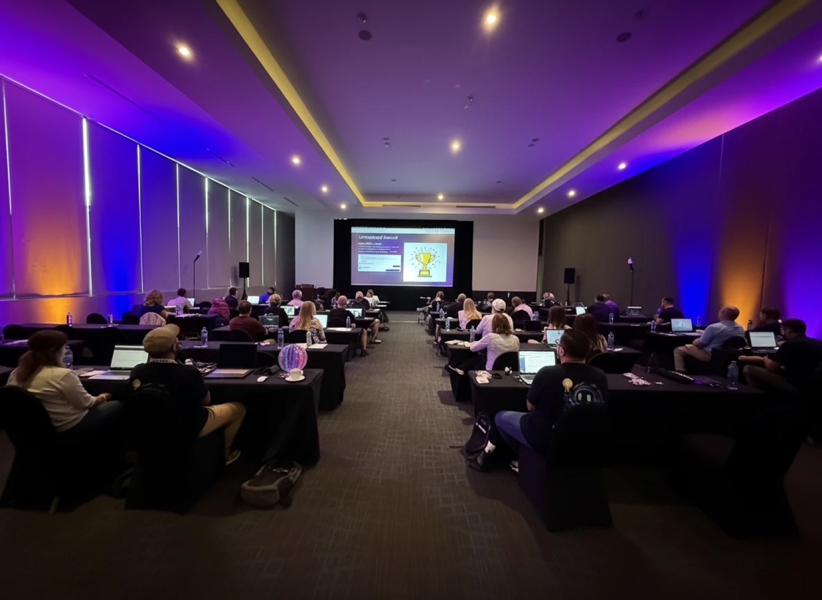 The AI Unleashed Intensive room in session, lit in purple and gold