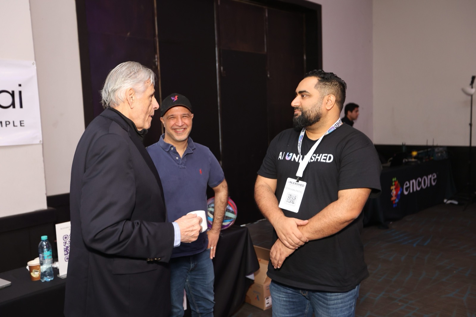 Fer Patel in conversation with two attendees at AI Unleashed Intensive